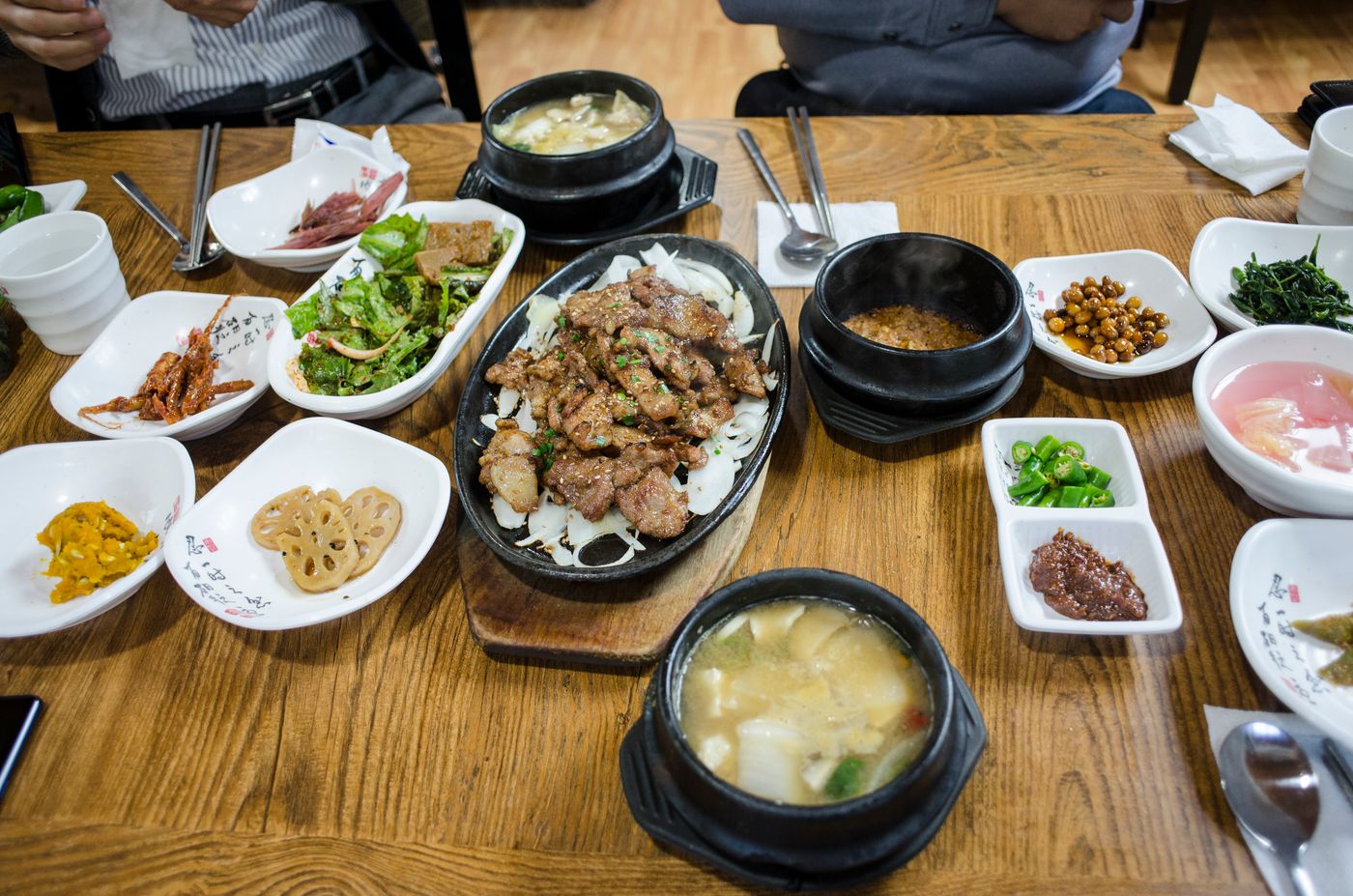 나무 식탁 위에 차려진 불고기와 찌개, 반찬